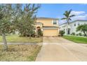 Two-story house with a tan exterior, two-car garage, and landscaping at 534 19Th Nw St, Ruskin, FL 33570