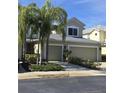Two-story house with a two-car garage, palm trees, and well-manicured lawn at 558 Harbor Ridge Dr, Palm Harbor, FL 34683