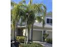 Tan two-story house with a two-car garage and lush landscaping at 558 Harbor Ridge Dr, Palm Harbor, FL 34683