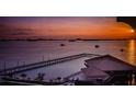 Stunning sunset over the water, with a pier and clubhouse visible at 632 Edgewater Dr # 439, Dunedin, FL 34698