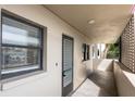 A hallway with light walls, tiled floors, and a door to a condo at 7050 Sunset S Dr # 211, South Pasadena, FL 33707