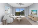 Living room with a modern sofa, TV, and access to a balcony at 7050 Sunset S Dr # 211, South Pasadena, FL 33707