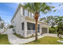 Two-story house with a walkway, palm tree, and gray garage door at 7714 S West Shore Blvd, Tampa, FL 33616