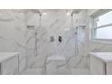Large bathroom with double shower heads and marble tile at 8111 Tar Hollow Dr, Gibsonton, FL 33534