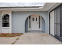 White front door with arched entryway, adding curb appeal to the home at 10237 Carrin Rd, Spring Hill, FL 34608