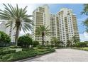 Luxury high-rise building with palm trees and landscaped grounds at 1200 Gulf Blvd # 204, Clearwater Beach, FL 33767