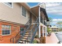 Exterior brick and siding building with a metal staircase leading to a balcony at 200 Country Club Dr # 802, Largo, FL 33771