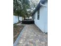 Spacious backyard with a brick patio, deck, and lush greenery at 3005 E 148Th Ave, Lutz, FL 33559