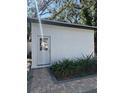 White storage shed with a paved pathway and landscaping at 3005 E 148Th Ave, Lutz, FL 33559