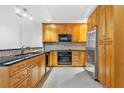 Modern kitchen with wood cabinets, granite counters, and stainless steel appliances at 331 Cleveland St # 315, Clearwater, FL 33755