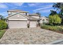 Two-story house with a three-car garage and stone accents at 11550 Biddeford Pl, New Port Richey, FL 34654
