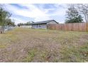 Gray house with wooden fence and expansive lawn at 14430 10Th. St, Dade City, FL 33523