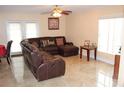 Spacious living room featuring a large sectional sofa and tile flooring at 17346 Mint Leaf Ln, Land O Lakes, FL 34638