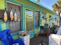 Colorful bungalow with porch, landscaping, and patio furniture at 18006 4Th E St, Redington Shores, FL 33708