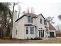 Two-story white brick home with brown roof, showcasing the side profile at 19018 Geraci Rd, Lutz, FL 33548