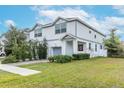 Two-story house with gray siding, attached garage, and well-maintained lawn at 2704 W Gray St # B, Tampa, FL 33609