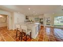 Spacious kitchen boasts modern white cabinets, large island, and terracotta tile floors at 2801 Hibiscus W Dr, Belleair Beach, FL 33786