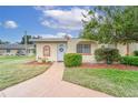 Condo exterior showcasing walkway, landscaping, and entryway at 401 Dorchester Pl # 52, Sun City Center, FL 33573