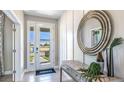 Bright and airy entryway with a large circular mirror and console table at 6724 Broad River Ave, Land O Lakes, FL 34638