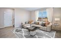 Living room featuring a beige sofa, coffee table, and large window at 7196 Beaverhead Ln, Land O Lakes, FL 34638