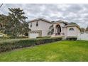 Two-story house with a landscaped lawn, stone accents, and a two-car garage at 720 Sunset Dr, Tarpon Springs, FL 34689