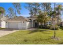 Single-story house with a two-car garage and lush green lawn at 10500 Old Tampa Bay Dr, San Antonio, FL 33576