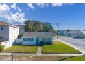 Charming single story home with a manicured lawn and teal door at 312 S Arrawana Ave, Tampa, FL 33609