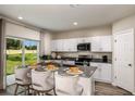 Modern kitchen with white cabinets, stainless steel appliances, and an island at 37268 Sagemoor Dr, Zephyrhills, FL 33541