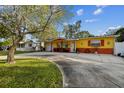 Bright yellow ranch home with a large yard and circular driveway at 4360 82Nd N Ave, Pinellas Park, FL 33781