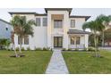 Modern two-story home with a landscaped lawn and walkway at 716 S Lois Ave, Tampa, FL 33609