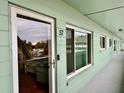 View down a hallway with a light green wall and a door to a condo at 2043 Denmark St # 57, Clearwater, FL 33763