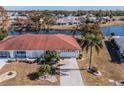 Single-story home with red tile roof, situated on a canal at 1207 Bluewater Dr, Sun City Center, FL 33573