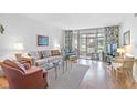Living room with sofa, chairs, and view to patio at 12200 Vonn Rd # 1106, Largo, FL 33774