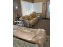 Living room with floral sofas and yellow pillows at 12501 Ulmerton Rd # 140, Largo, FL 33774