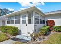 Front view of house with enclosed porch and landscaping at 1305 Whitebridge Dr # B, Palm Harbor, FL 34684