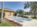 Two-car garage with a long driveway and mature trees at 17409 New Cross Cir, Lithia, FL 33547