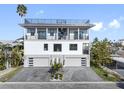 Modern coastal home with a rooftop deck and three-car garage at 18077 3Rd St, Redington Shores, FL 33708