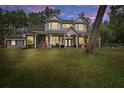 Two-story home with wrap-around porch, lit at night at 19387 Hidden Oaks Dr, Brooksville, FL 34604