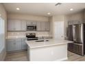 Modern kitchen with gray cabinets, quartz countertops, and stainless steel appliances at 2049 Stillview Pass, Zephyrhills, FL 33541