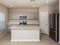Modern kitchen with gray cabinets, quartz countertops, and stainless steel appliances at 2049 Stillview Pass, Zephyrhills, FL 33541