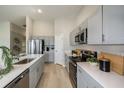 Modern kitchen with gray cabinets, stainless steel appliances, and an island at 2103 Stillview Pass, Zephyrhills, FL 33541