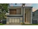 Modern home with a clean design, featuring a glass garage door and a paved driveway at 3010 W Trilby Ave, Tampa, FL 33611