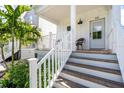 Front porch with white railings and wooden steps leading to the entrance at 340 6Th E St, Bradenton, FL 34208