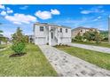 Modern two-story home with a gray paver driveway and green lawn at 3431 Palometa Dr, Hernando Beach, FL 34607
