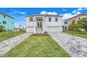 White two-story house with gray paver driveway and landscaping at 3431 Palometa Dr, Hernando Beach, FL 34607