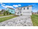 Two-story white house, gray pavers, and nicely landscaped lawn at 3431 Palometa Dr, Hernando Beach, FL 34607