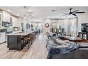 Open concept living space featuring a kitchen island and spacious leather sectional sofa at 34432 Wynthorne Pl, Wesley Chapel, FL 33545