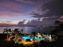 Night view of condo pool area with dramatic sunset and waterfront background at 5155 Isla Key S Blvd # 402, St Petersburg, FL 33715