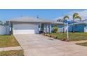 Newly renovated home exterior with a white garage door and landscaped lawn at 6025 Venetian Ne Blvd, St Petersburg, FL 33703