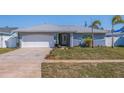 Newly renovated home exterior with a white garage door and landscaped lawn at 6025 Venetian Ne Blvd, St Petersburg, FL 33703